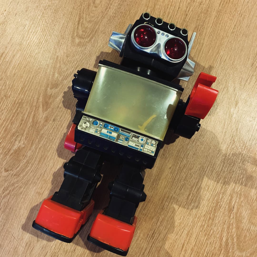 Vintage toy robot with red and black color scheme.