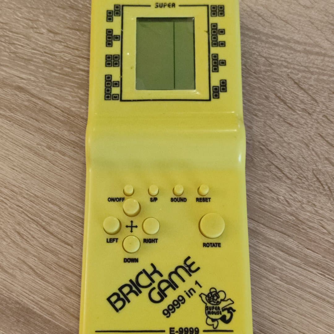 Vintage yellow handheld Brick Game 9999 in 1 console.
