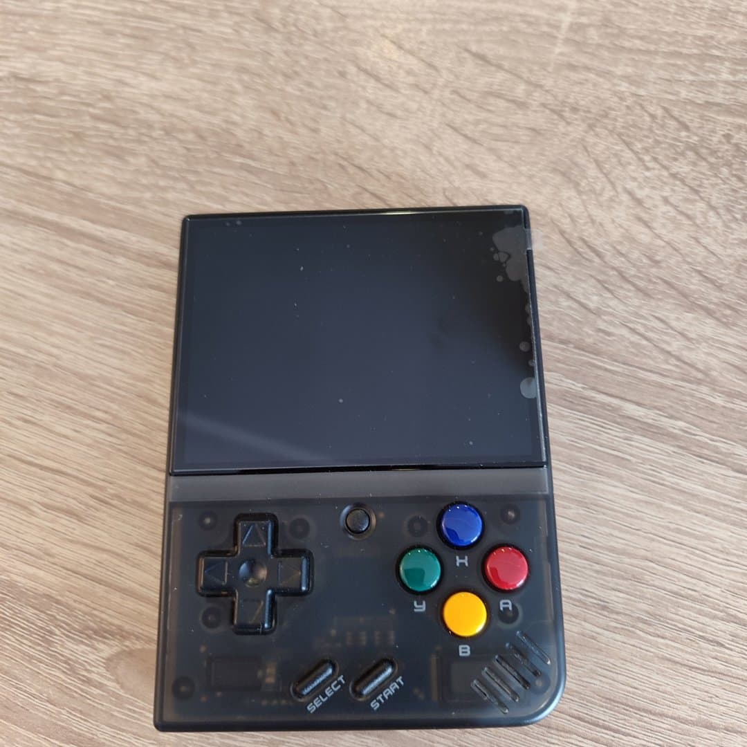 A handheld retro gaming console with a black transparent shell. Miyoo Mini+