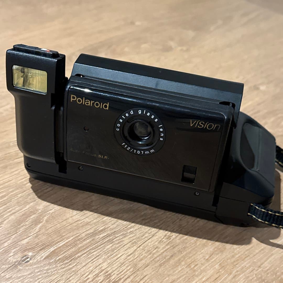 A black Polaroid Vision instant camera with a flash.