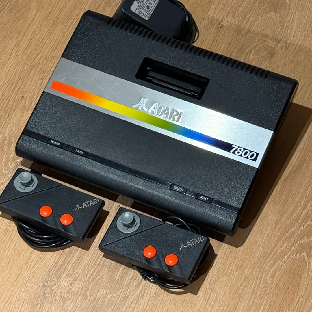 Vintage Atari 7800 ProSystem console with two controllers and power adapter.