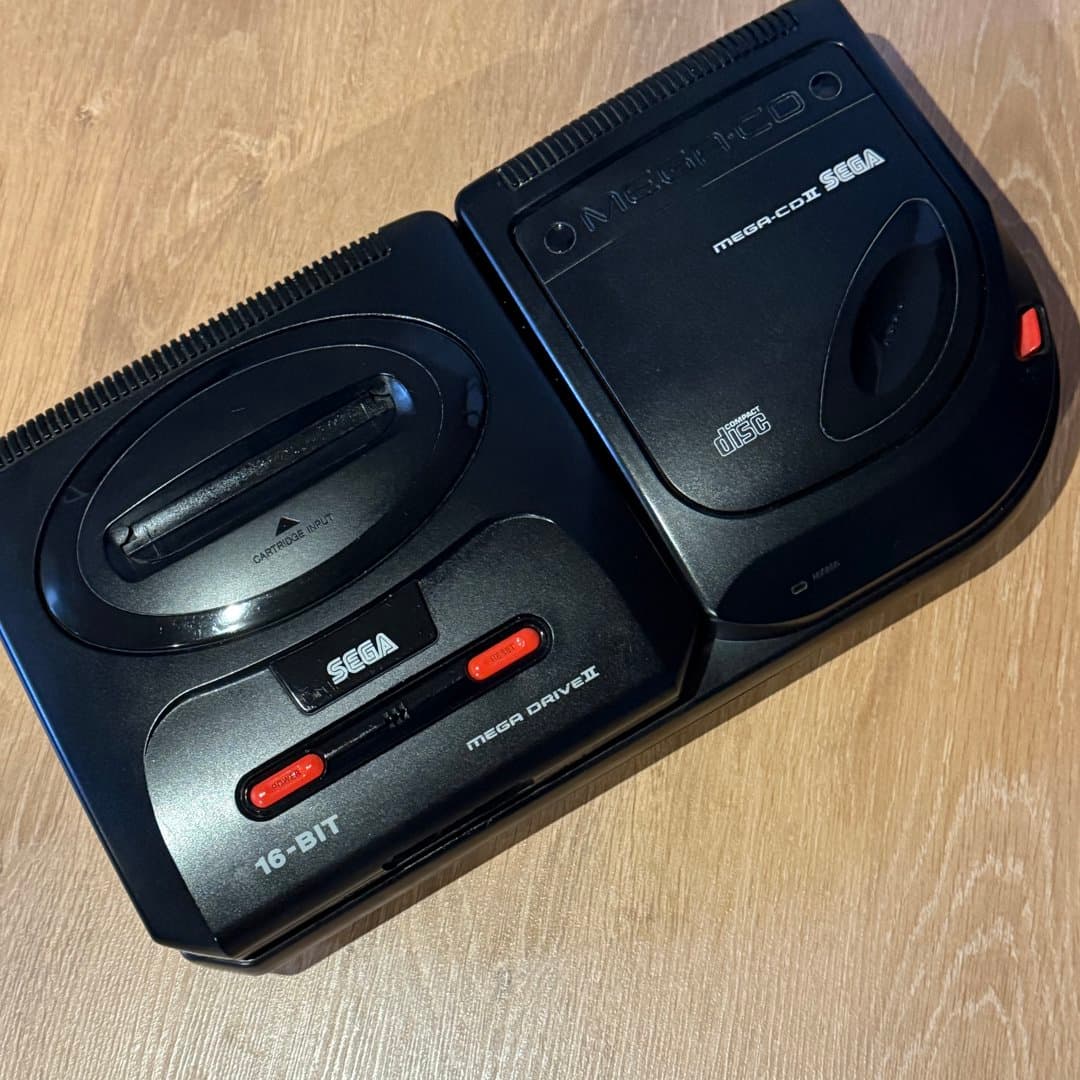 A retro Sega Mega Drive II console with the Mega-CD II attachment for classic gaming.
