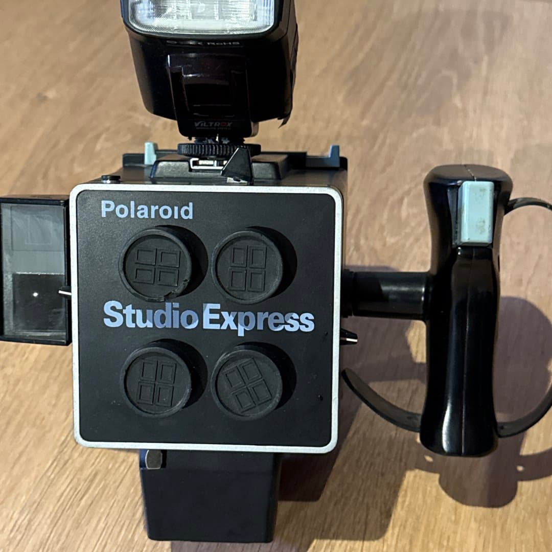 Polaroid Studio Express instant camera system with external flash and handle.
