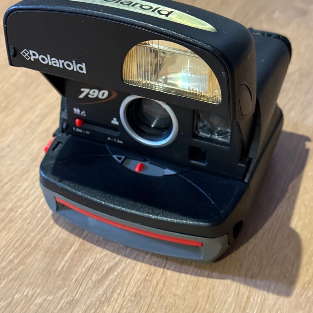 Vintage black Polaroid 790 instant camera with built-in flash.