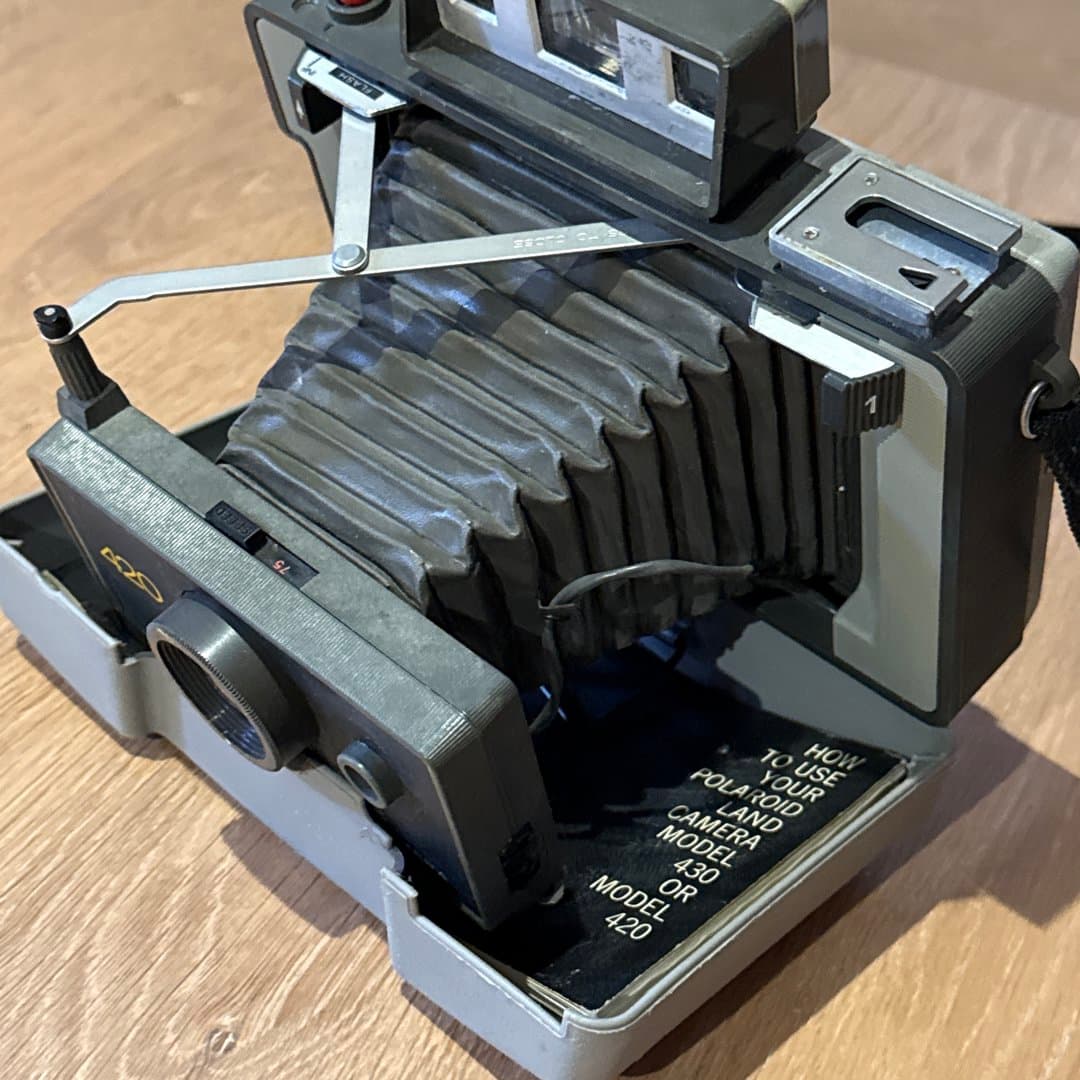 Vintage Polaroid Automatic Land Camera 420, a classic instant film camera with its original manual.