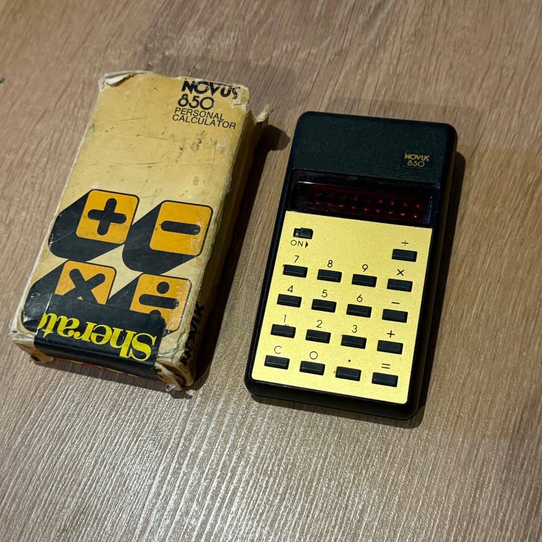 Vintage Novus 850 personal calculator with gold keypad, red LED display, and original box. - Photo 1