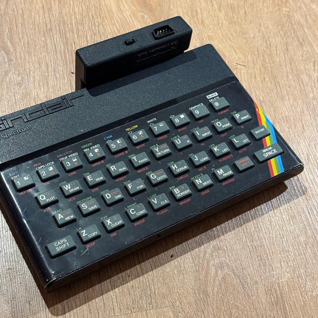 A vintage Sinclair ZX Spectrum home computer with its iconic rubber keyboard and expansion port. - Photo 1