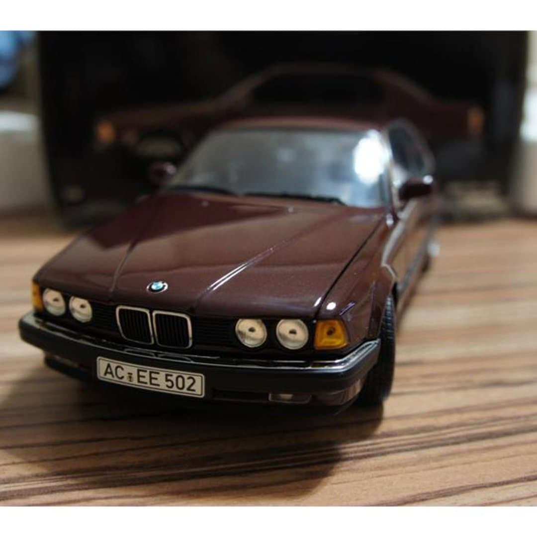 Collectible maroon BMW E32 die-cast Minichamps model car.