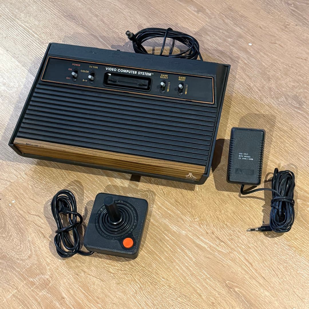 Vintage Atari 2600 woody 4 Switch Video Computer System console with joystick and power adapter.