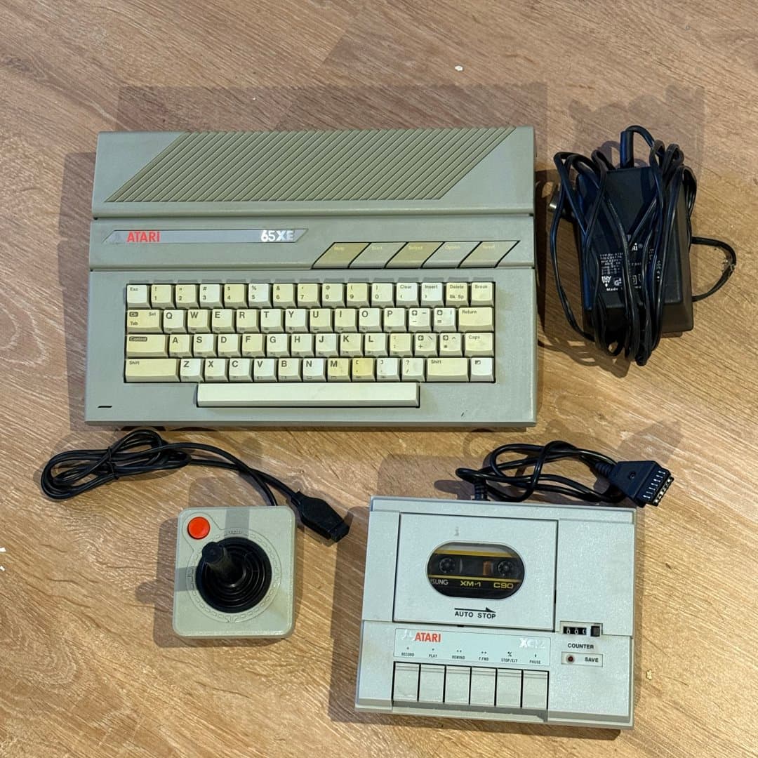 Vintage Atari 65XE home computer with cassette drive, joystick, and power adapter. - Photo 1