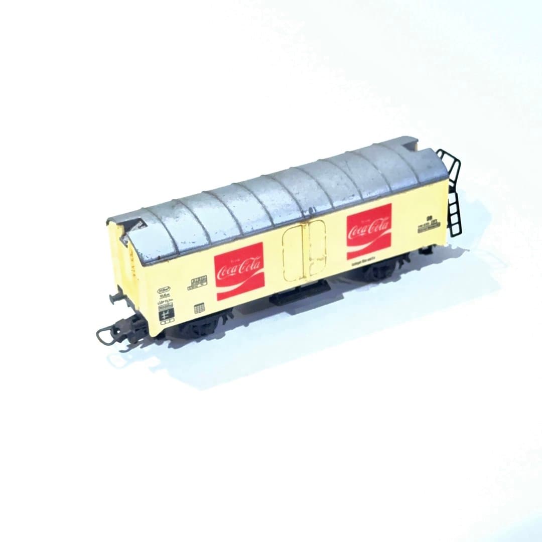 Collectible Coca-Cola branded model train freight car with cream body and grey roof. HO Scale