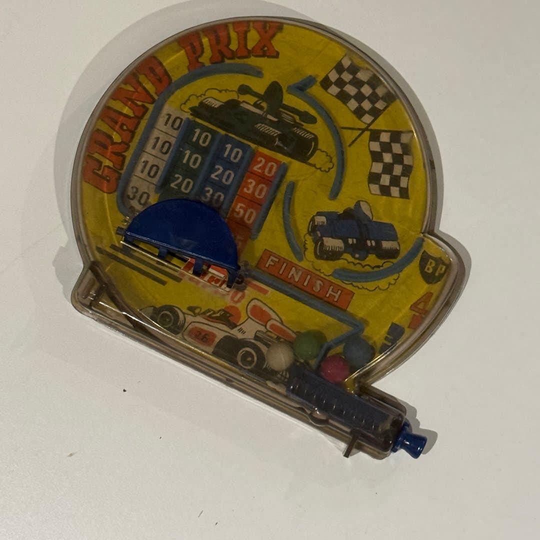 Vintage Grand Prix race car dexterity game with marbles and score holes.