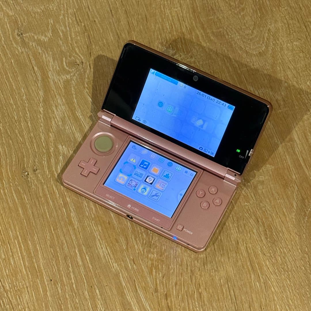 Pink Nintendo 3DS handheld gaming console, viewed from the back.
