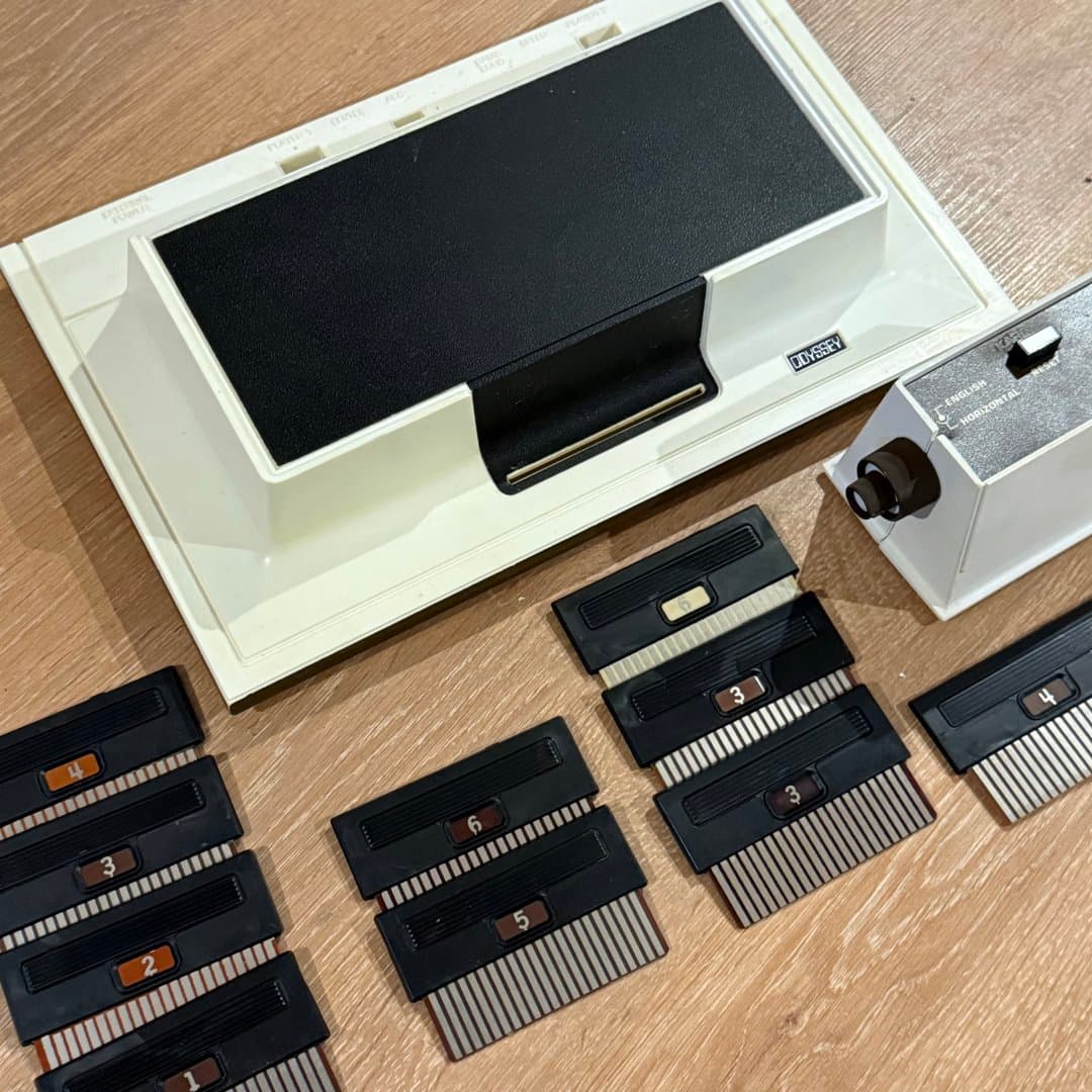Vintage Magnavox Odyssey console with game cartridges and controller, a piece of gaming history.