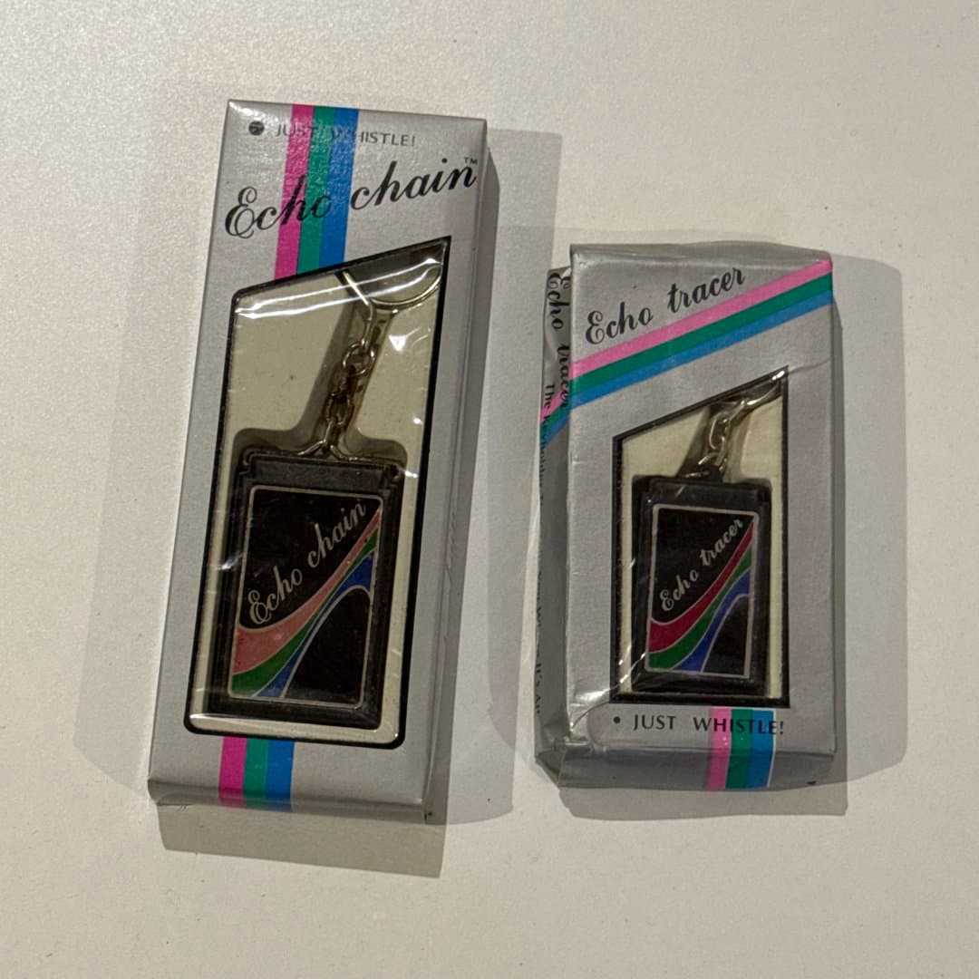 Retro whistle keychains, 'Echo chain' and 'Echo tracer', new in box.