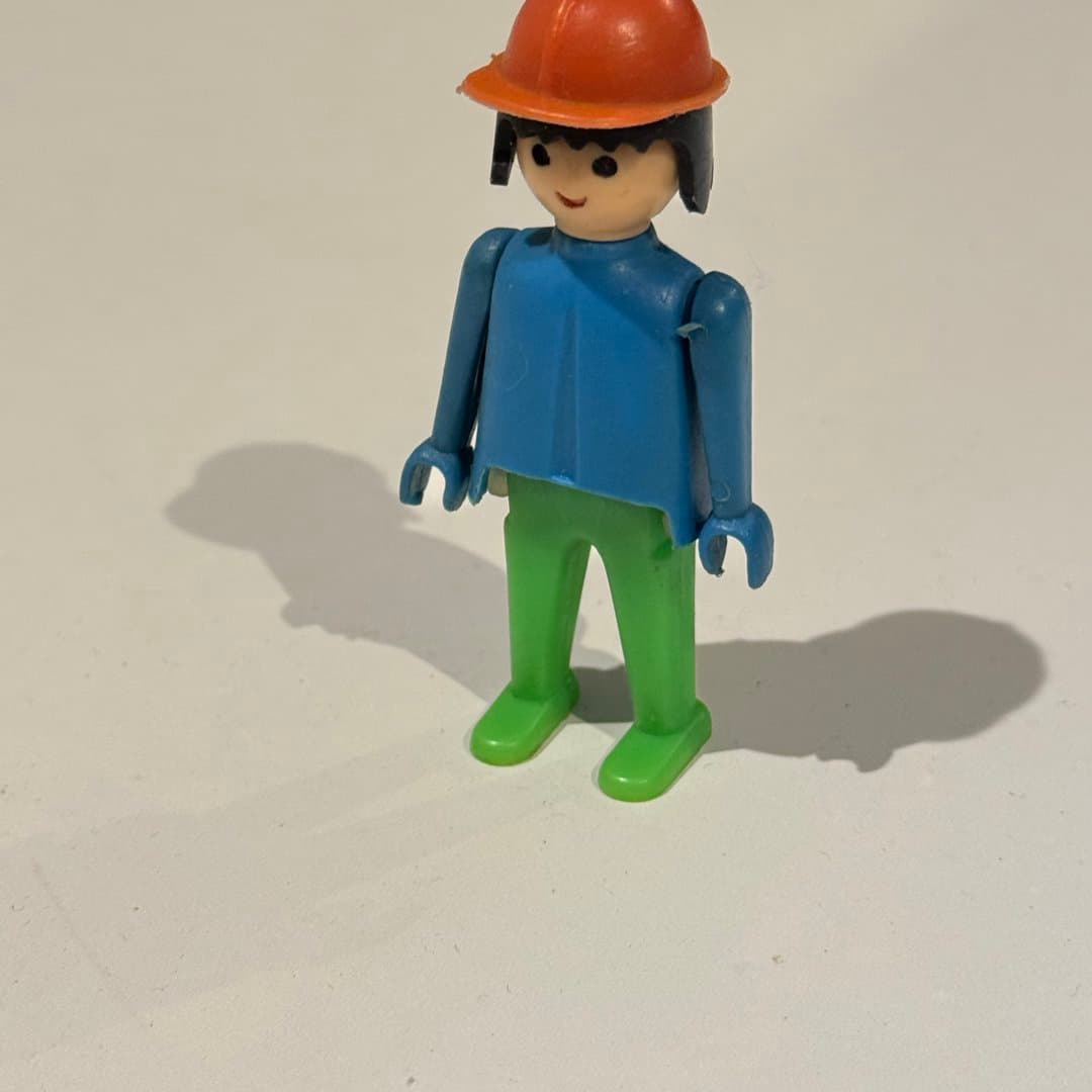 Pilsan figure with orange hard hat, blue shirt, and green pants. - Photo 1