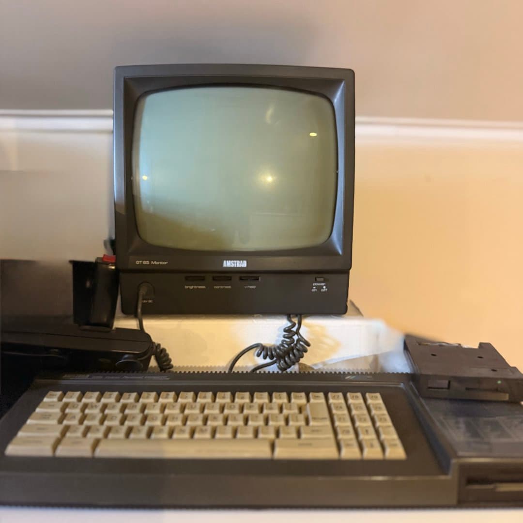 Vintage Amstrad personal computer system with a CRT monitor, integrated keyboard, and disk drive.
