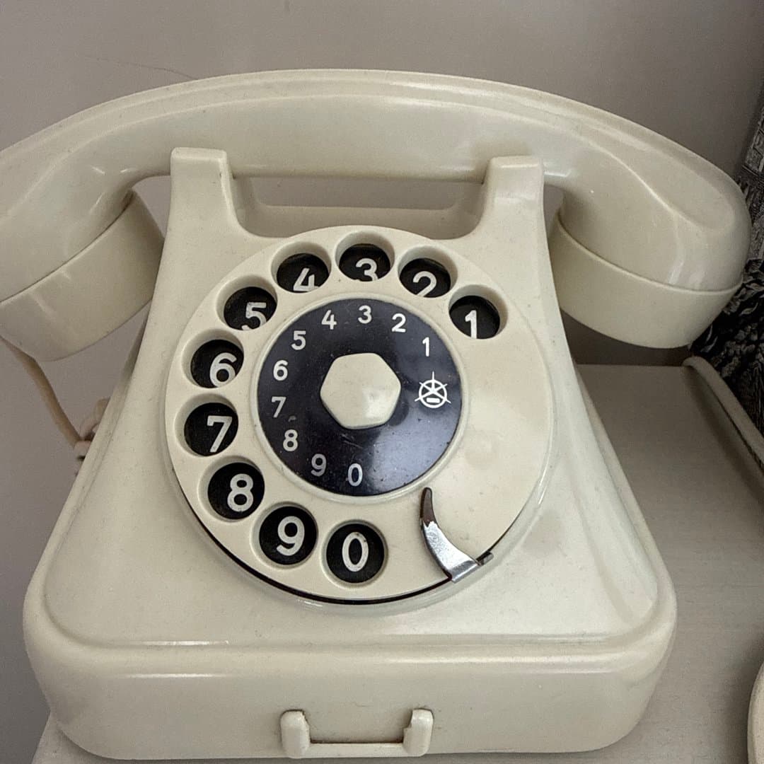 Vintage cream rotary dial telephone for a retro communication experience.