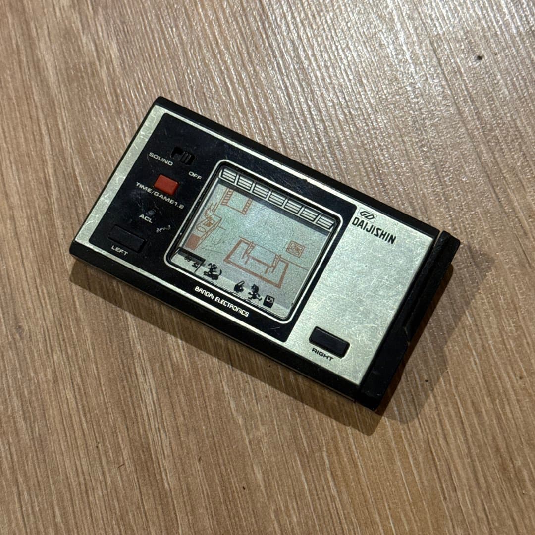 Vintage Bandai Daijishin handheld LCD game with an earthquake theme.