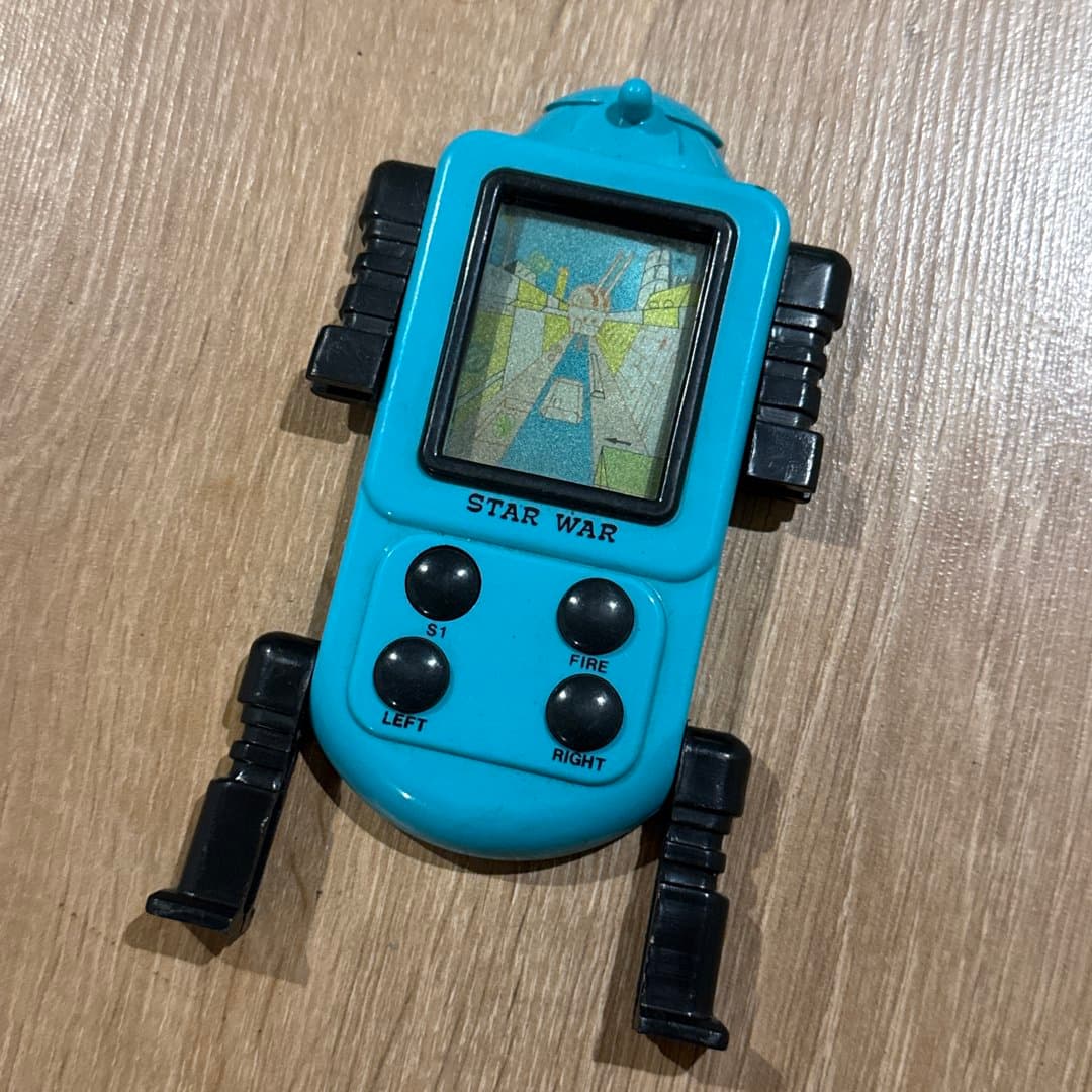 Retro blue robot-shaped handheld electronic game with "Star War" title and simple LCD screen.