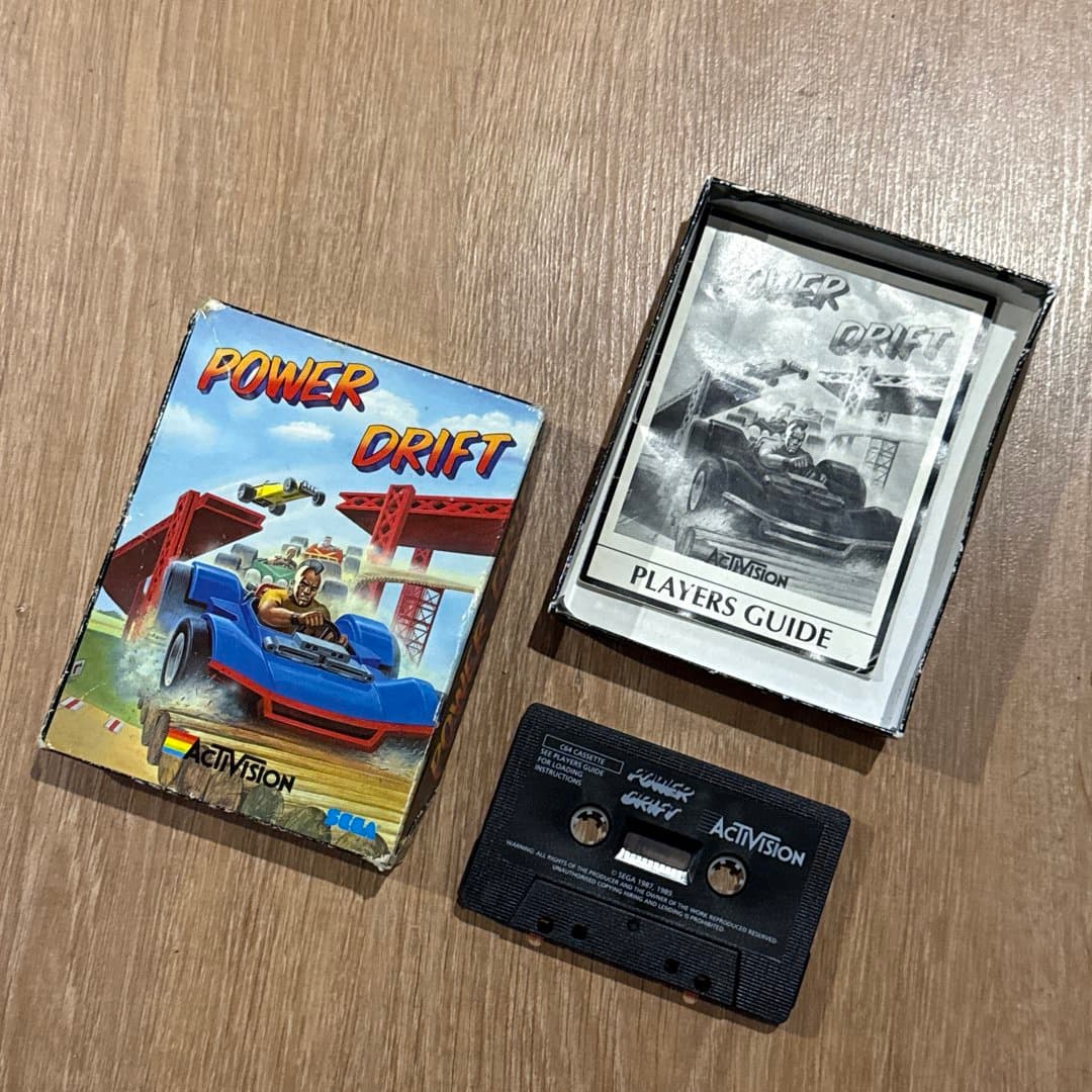 A vintage Power Drift racing game for Commodore 64, including cassette, box, and player's guide.