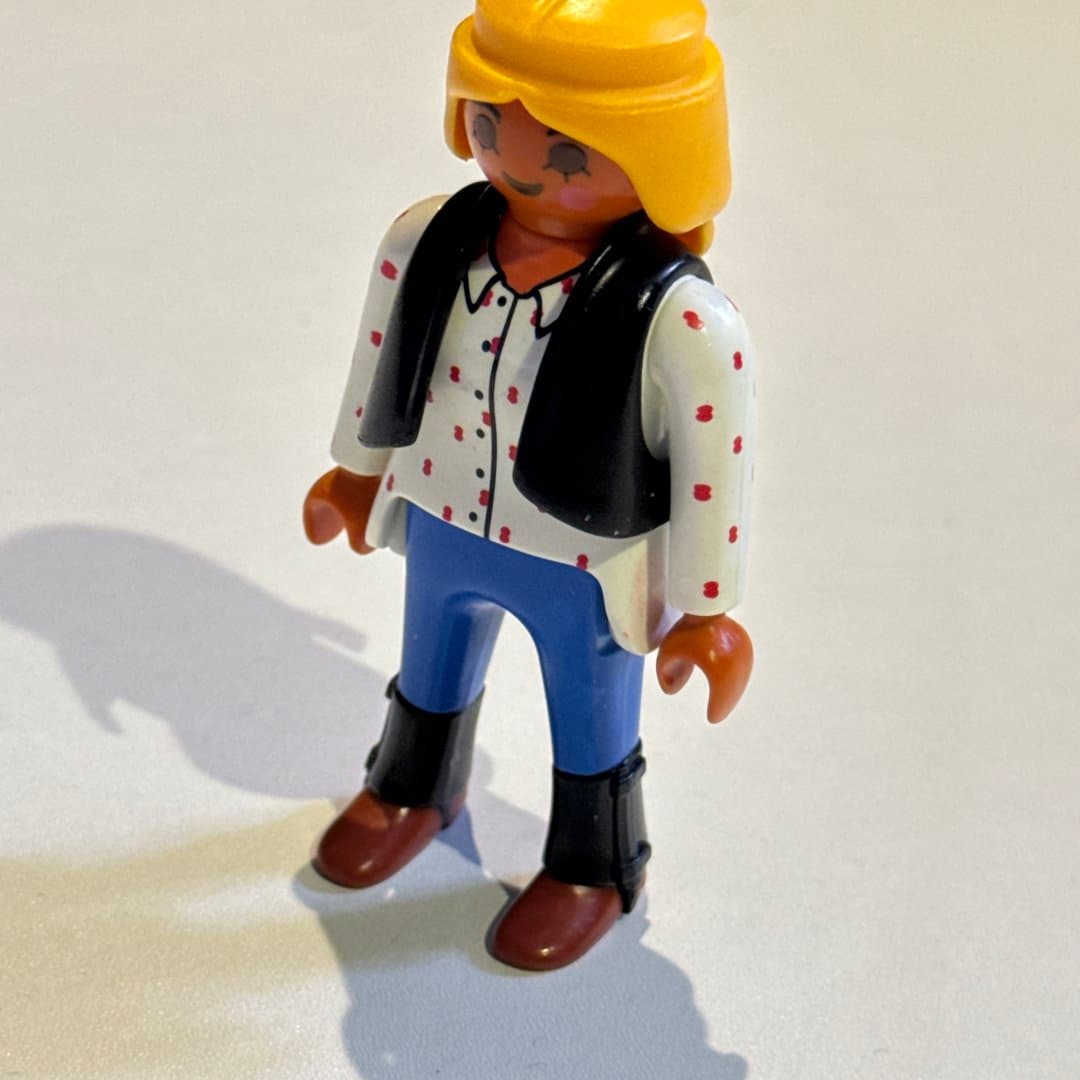 Playmobil Geobra character with yellow hair, white polka dot shirt, black vest, and blue pants. - Photo 1