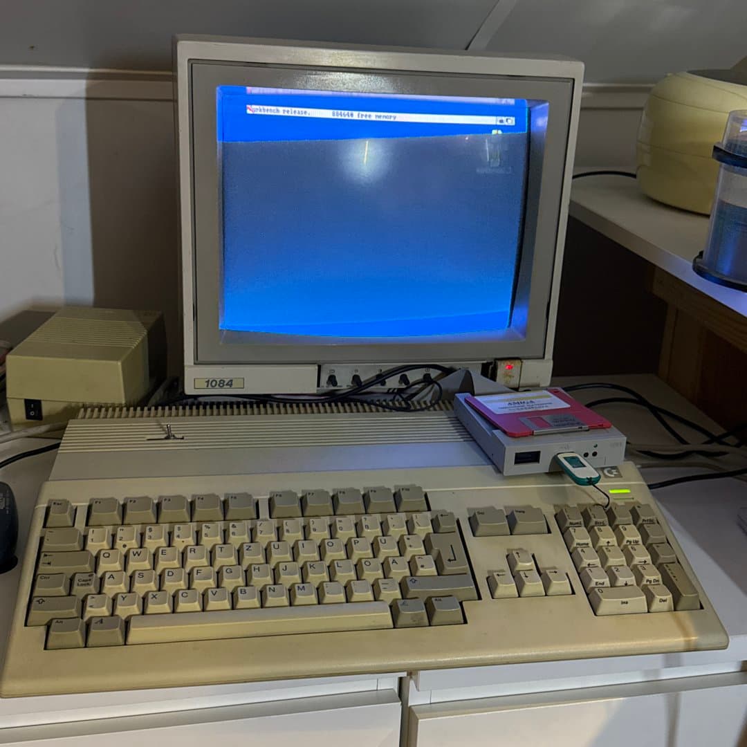 Vintage Amiga computer setup with a Commodore 1084 monitor and modern drive emulator.